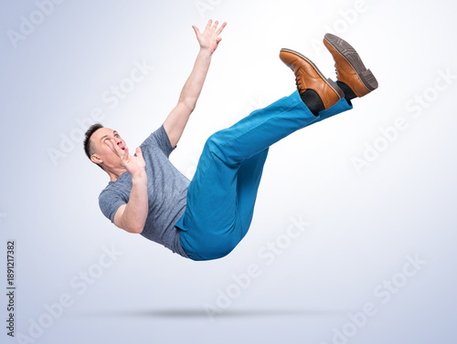 Photography Man falling in mid air isolated on white background as a metaphor of failure, career collapse, financial crisis, risk, mistake and loss of control