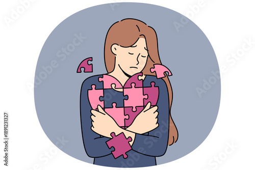 Sad woman holds disintegrating heart, symbolizing restoration of psyche after breaking up with guy. Girl with heart from puzzle, for concept of oncological diseases and cardio organ cancer