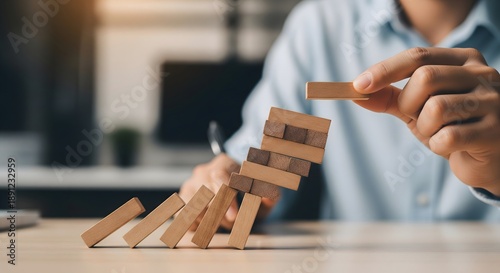 Risk management concept with hand preventing wooden blocks from falling, business stability and crisis prevention strategy, decision making and control, leadership and safety planning