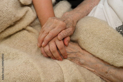 Fényképezés Hands of an elderly woman holding the hands of a child