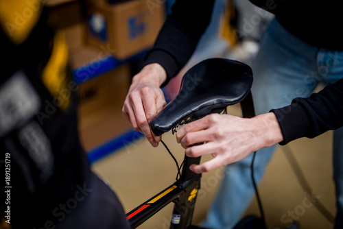 Mechanic adjusting racing bike saddle for optimal performance