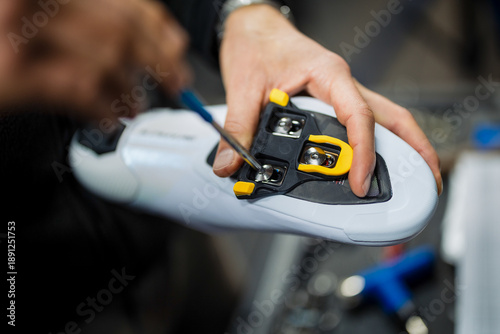 Εκτύπωση καμβά Cyclist adjusting cycling shoe cleats using a screwdriver