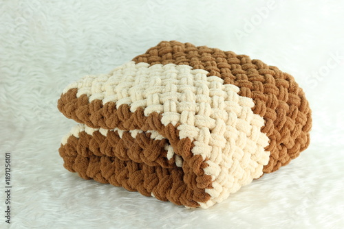 Handmade beige and brown puffy blanket with large loops on furry white blanket.