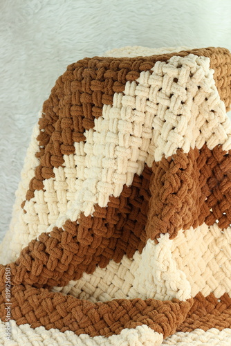 Handmade beige and brown puffy blanket with large loops on furry white blanket.
