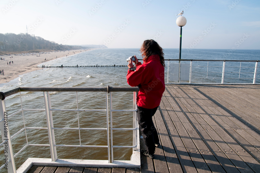 Obraz premium kobieta z aparatem na molo