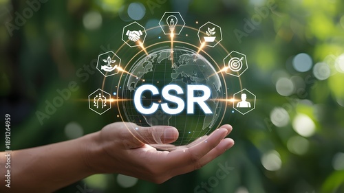 Corporate social responsibility concept: hand holding a glowing earth with csr text and related icons on a green bokeh background