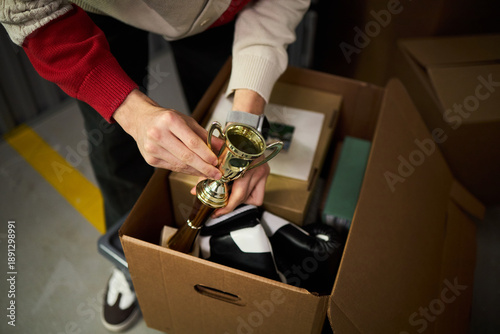 Fotografie Young adult Caucasian man packing cardboard box with personal belongings, holdin