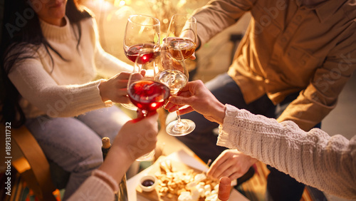 Fotografie Friends clinking wine glasses during home wine tasting evening