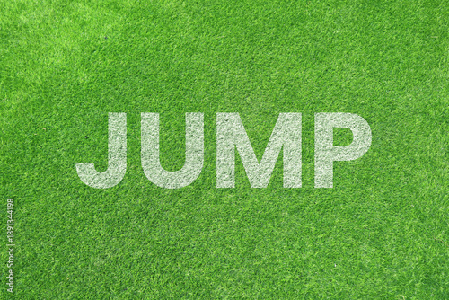 Obraz na płótnie Bold white JUMP text painted on a lush green grass background