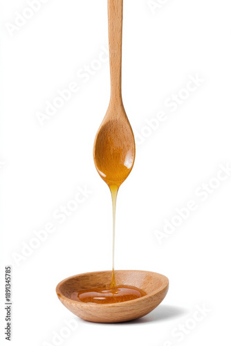 Wallpaper Mural Golden honey dripping from wooden spoon into bowl on white background Torontodigital.ca