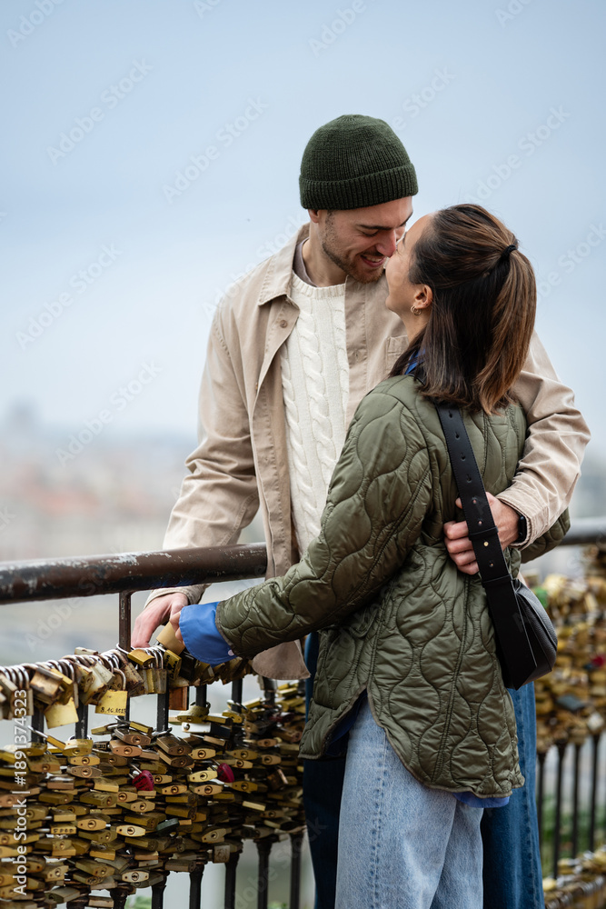 Fototapeta premium Loving couple attaching a padlock of love