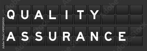 Black color analog flip board with word quality assurance on gray background