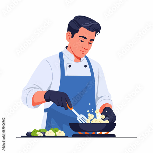 A male chef in a white jacket and blue apron cooking food in a pan with a spatula, preparing a meal on a stove with vegetables nearby.