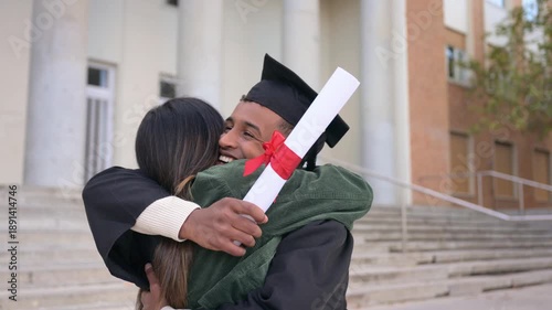 Young man hugging woman celebrating university graduation