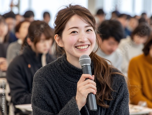 Plakat 講義室でマイクを手に発言する笑顔の女子学生が意見を述べるシーン
