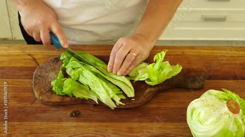 Woman cutting iceberg lettuce for salad
