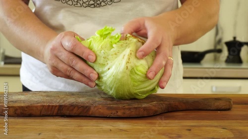 Woman cutting iceberg lettuce for salad

