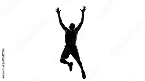 Silhouette of a basketball player jumping high reaching for the ball.