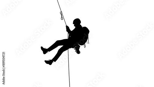 Silhouette of a person rappelling down a rope.