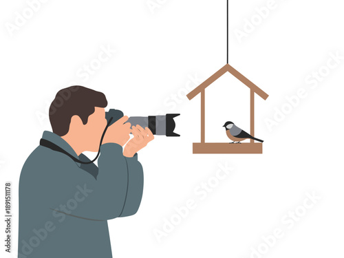 A photographer captures a bird at a feeder. A man with a camera focuses on a small bird in a wooden house. Nature photography hobby.