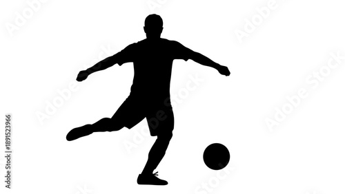 Silhouette of a soccer player kicking a ball during a game.