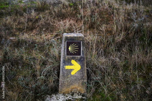Landmark of the Camino de Santiago with the yellow arrow pointing the correct direction to pilgrims and the tile with the star
