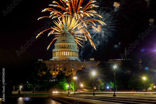 Fotografie Fireworks burst above Capitol building as people enjoy celebration on Independence day night in Washington D