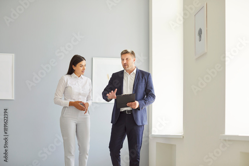 Obraz na płótnie Man professional real estate agent giving a tour around a new apartment or newly