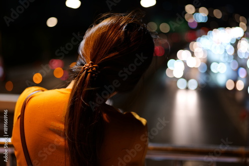 Woman Standing on Bridge Watching City Traffic at Night