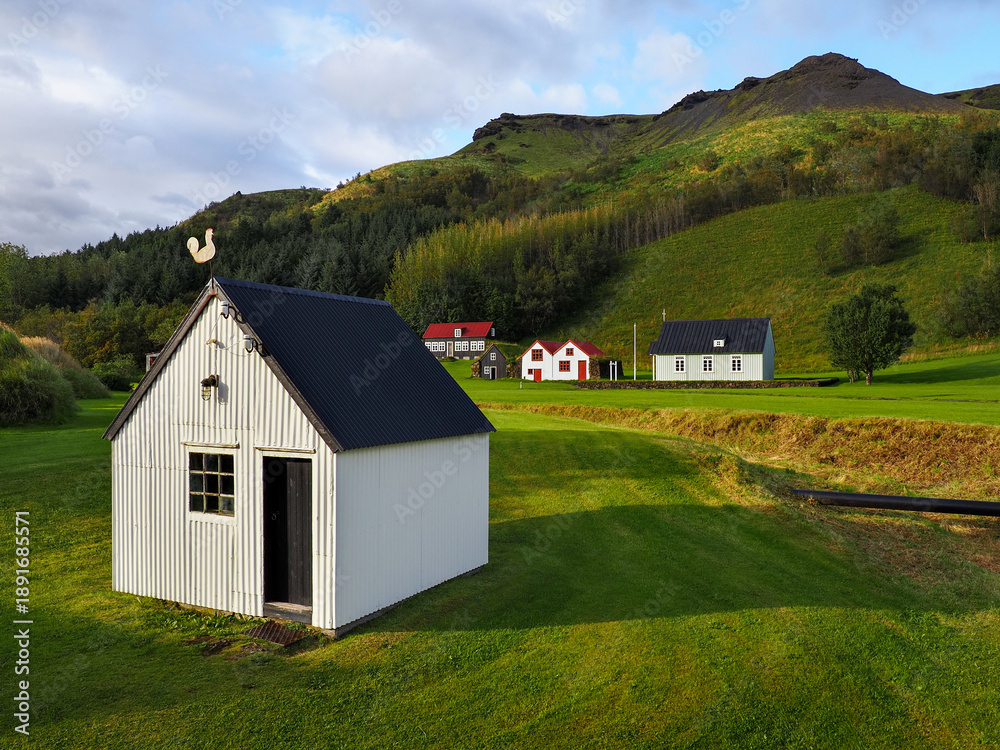 Obraz premium Small Icelandic village, Skógar church or Skógakirkja. Skógasafn - open air complex exploring early Icelandic history, heritage relics and wooden turf-houses. Safnavegur, Skógar, Iceland.