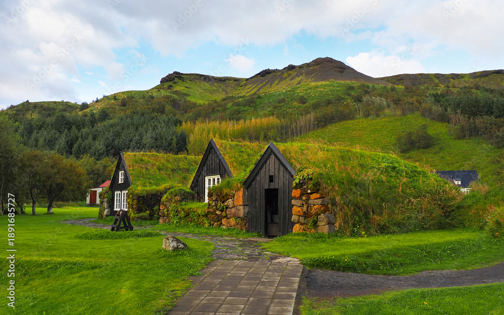 Fototapeta premium Ancient Icelandic village with old wooden stone turf-houses. Skógasafn, beautiful open air complex exploring early Icelandic history and heritage relics. Safnavegur, Skógar, Iceland.