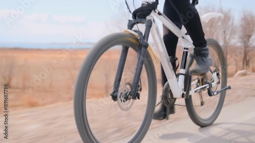 Wallpaper Mural Fast male cyclist riding bicycle in open field, intense winter training on rural road through vast grasslands, endurance workout, outdoor fitness, solo athlete practicing long-distance cycling. Torontodigital.ca