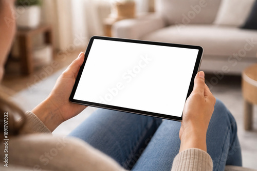 Person Holding Tablet with Blank White Screen on Sofa in Modern Living Room – UI UX App Mockup 