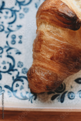 Fresh buttery croissant on ceramic plate
