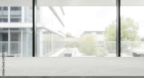Modern office interior with large windows overlooking a blurred urban landscape and trees in the distance