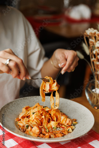 Tableau sur toile Close-up of female Hand Twirling Spaghetti on Fork in restaurant italian style