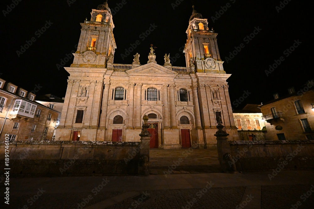 Fototapeta premium The illuminated facade of the Cathedral of Santa Maria in Lugo, Spain, photographed at night, reveals the majestic Gothic architecture and historical significance of this iconic church.