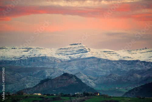 Fotografie Snowy mountains of Pena Cabarga at sunset seen from the bay of Santander, scenic