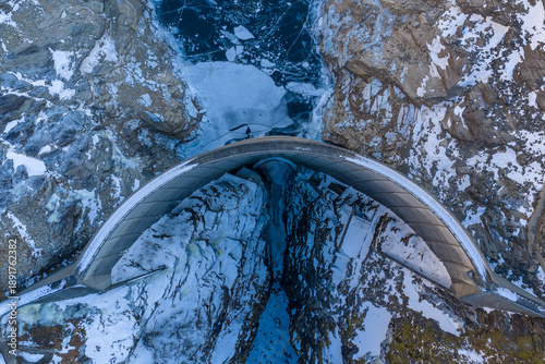 Fotografija Hoover dam, power plant with snow-covered mountains cradle a massive concrete dam above a frozen lake