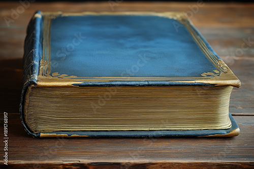 Vintage book with a blue cover and gold accents, resting on a rustic wooden table. A classic reading experience awaits.
