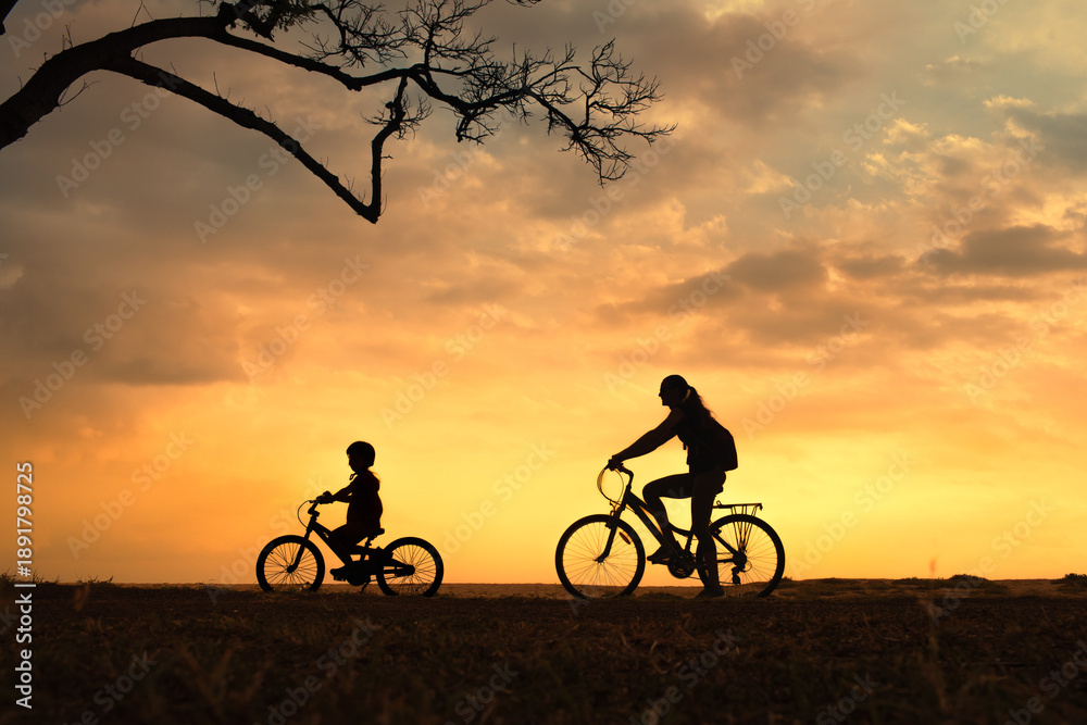 Obraz premium Parent and Child Riding Bicycles at Sunset