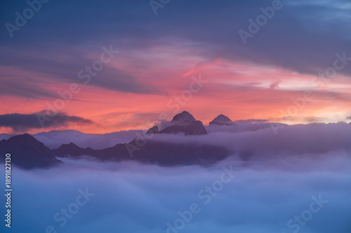 Wallpaper Mural Stunning high-altitude landscape featuring mountain peaks above a thick cloud layer under a vibrant purple and orange sunset. Ideal for travel and environmental themes. Torontodigital.ca