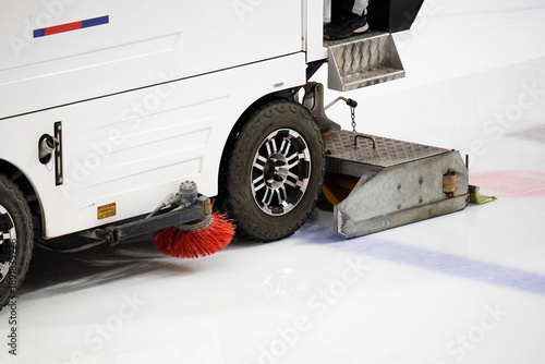 close-up view of an ice resurfacing machine, commonly known as a Zamboni, in operation on an ice rink