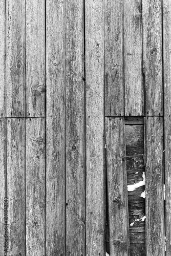 Old weathered wooden wall texture with a hole in black and white