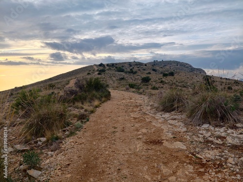 Sunset scenic walk, Evening illumination highlighting winding path and distant horizons landscape