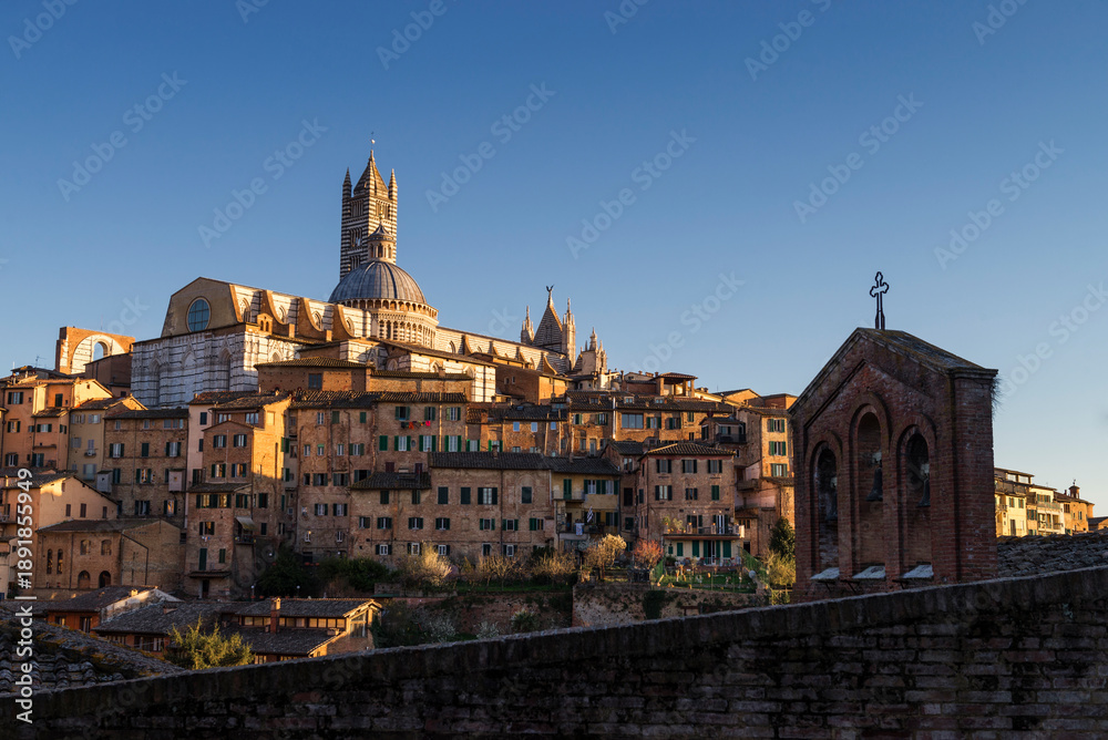 Obraz premium Siena, Italy - March 27, 2019. Scenic view of old town of Siena in a sunset light