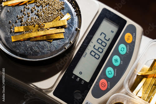 Photos Jeweler carefully weighing gold materials before melting stage.
