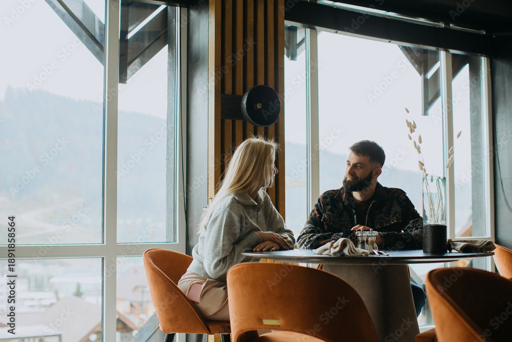 Naklejka premium Couple interacting in modern hotel lounge restaurant