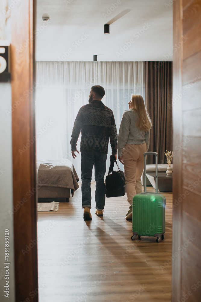 Fototapeta premium Couple entering hotel room enjoying vacation travel