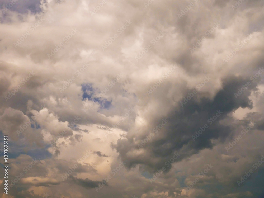 Obraz premium The sky is cloudy and the sun is shining through the clouds. The sky is blue and the clouds are white
